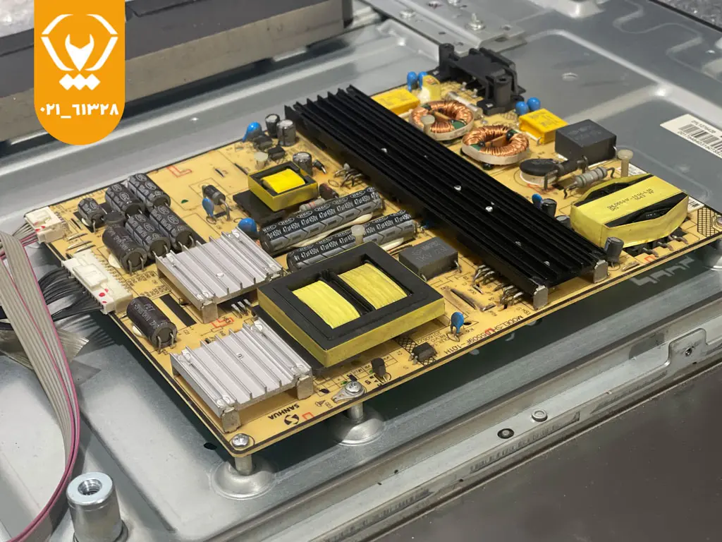 تکنسین در حال بررسی برد پاور و مینبرد پشت تلویزیون الجی برای رفع داغ شدن بیش از حد